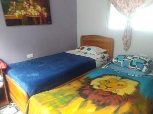 1 dormitorio con 2 camas y una pintura de un león en Hospedaje Roca Firme, en Choachí