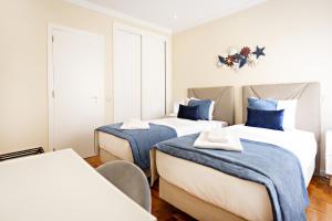 two beds in a room with blue and white at Blue Peacock in Faro +11 photos