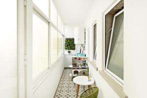 a hallway with a table and chairs and windows at Blue Peacock in Faro