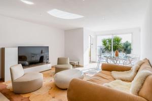 uma sala de estar com um sofá e uma televisão em Sunny Dreams : villa de plain-pied, vue mer em La Ciotat