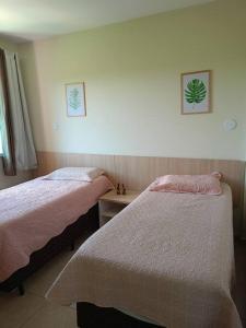 a bedroom with two beds and a table and a window at Apartamento em Caldas Novas in Caldas Novas