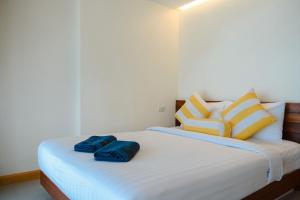 Una cama con dos almohadas azules encima. en Samed Seaside Resort - เสม็ด ซีไซด์ รีสอร์ท, en Ko Samed