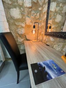 un libro seduto su un tavolo di legno con una lampada di Casa Soderini a Tarquinia