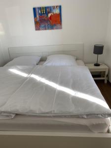 1 cama con edredón blanco en un dormitorio en Ferienwohnung zentral an der Moselpromenade, en Zell an der Mosel