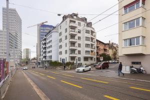 una persona che cammina per una strada di città con edifici di Grand Terrace Suite Elite 4,5BR BA52 a Zurigo