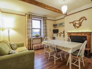 a living room with a table and a couch at Rowan Tree House in Brora