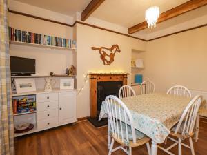 a dining room with a table and a fireplace at Rowan Tree House in Brora +12 photos