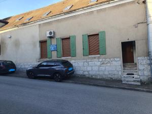 um carro estacionado em frente a um edifício com persianas verdes em Vernon Rive Droite em Vernon