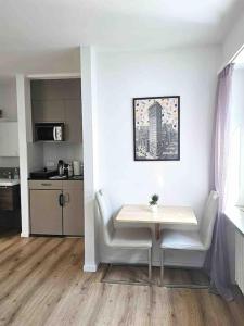 uma mesa branca e cadeiras num quarto com uma cozinha em Heart of Zurich Modern Studio HG14 em Zurique