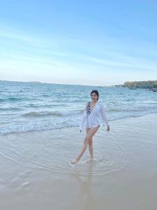 a woman standing in the water on the beach at Samed Seaside Resort - เสม็ด ซีไซด์ รีสอร์ท in Ko Samed