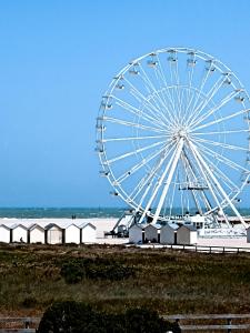 a large ferris wheel in front of a beach at Riva Bella chez Caraphou in Ouistreham