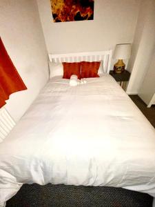 Una cama blanca con un animal de peluche encima. en Luxurious Suite: Nottingham Room, en Nottingham