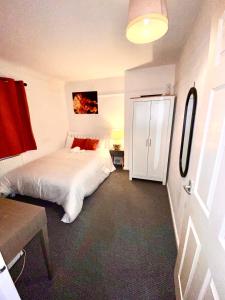 a bedroom with a white bed and a white cabinet at Luxurious Suite: Nottingham Room in Nottingham