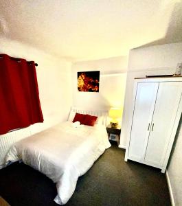 a bedroom with a white bed and a red curtain at Luxurious Suite: Nottingham Room in Nottingham