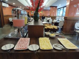 a table with plates of cheese and a blender at Hotel Oscar Gold Savassi in Belo Horizonte