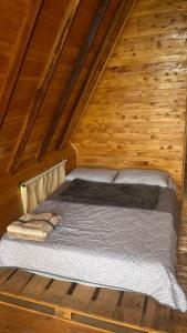 a bed in the attic of a wooden cabin at Lago Cristal Chalets in Los Santos