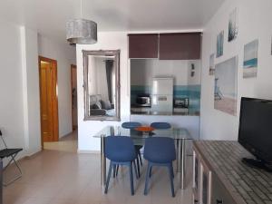 Il comprend un salon avec une table et des chaises ainsi qu'une cuisine. dans l'établissement Apto. Dunas Playa, à Isla Cristina