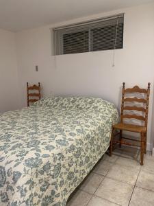 - une chambre avec un lit et deux chaises en bois dans l'établissement La Maison Tanguay, à Saguenay