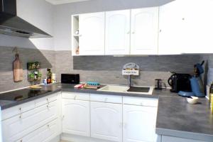 een keuken met witte kasten en een wastafel bij Beautiful apartment located 800 m from the Beach in Six-Fours-les-Plages