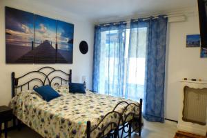 een slaapkamer met een bed met blauwe gordijnen en een raam bij Beautiful apartment located 800 m from the Beach in Six-Fours-les-Plages