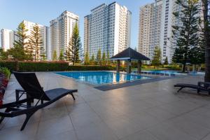 a pool with a chair and an umbrella and some buildings at Room 2222 - Wind Residences, Tower 5, Tagaytay, PH in Tagaytay