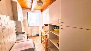 a small kitchen with a refrigerator and a sink at Trilo Torre - caratteristico trilo nel centro storico in Numana