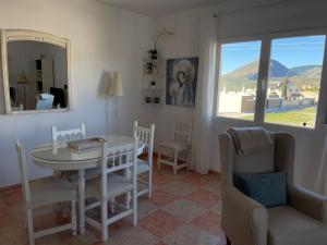 a dining room with a table and chairs and a window at Apartamento El Mirador de Sierra Mágina Noalejo entre Granada y Jaén in Noalejo