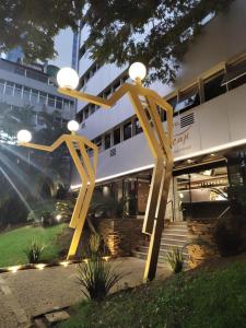 una grande scultura gialla di fronte a un edificio di Hotel Oscar Gold Savassi a Belo Horizonte
