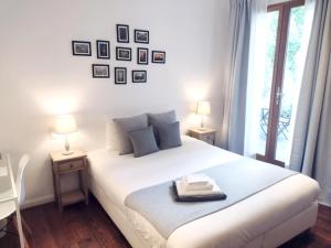 een slaapkamer met een groot wit bed met 2 lampen bij De Mot B&B in Brussel