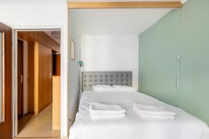 - une chambre avec un lit blanc et des serviettes dans l'établissement K&K Apartments Schönbrunn - Kingsize Bed & Netflix Self Check-In, à Vienne