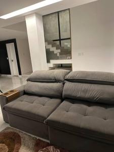 una sala de estar con un sofá marrón en una habitación en Casa Conteiner, en Itaboraí