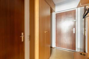 Cette chambre dispose d'une porte en bois et d'un couloir. dans l'établissement K&K Apartments Schönbrunn - Kingsize Bed & Netflix Self Check-In, à Vienne