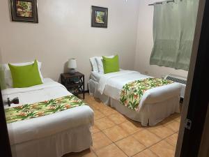 two beds in a room with green pillows at Paradise Island in Isabela