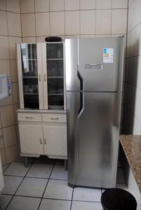a kitchen with a stainless steel refrigerator and cabinets at Apto Meia Praia in Itapema
