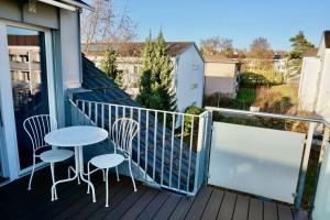 eine Veranda mit einem Tisch und Stühlen auf dem Balkon in der Unterkunft Sunrise Terrace 2,5 Room Apartment FR-31 in Wallisellen
