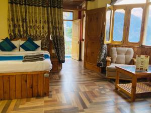 a bedroom with a bed and a chair and a table at Woods Villa Cottage, Manali in Manāli