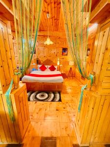 a bedroom with a bed in a wooden room at Woods Villa Cottage, Manali in Manāli