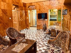 sala de estar con sillas de mimbre y mesa en Woods Villa Cottage, Manali en Manāli