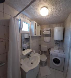 La petite salle de bains est pourvue d'un lavabo et de toilettes. dans l'établissement Sydney Apartment, à Bilice