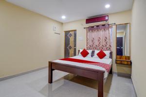 a bedroom with a bed with red pillows at OYO AR Guest House in Visakhapatnam