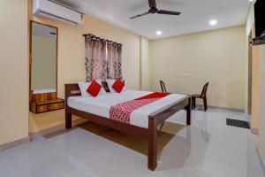 a bedroom with a bed with red pillows at OYO AR Guest House in Visakhapatnam