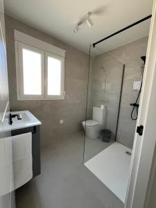 a bathroom with a shower and a toilet and a sink at La vía in Santa Eulalia