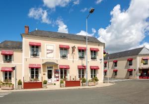 an empty street in front of a building with red awnings at Logis La Renaissance in Le Lude