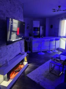 a living room with a fireplace and a tv at Cosy T2 au porte d’Orly-Rungis in Chevilly-Larue