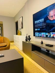 a living room with a large flat screen tv at Deserene apartment in Accra