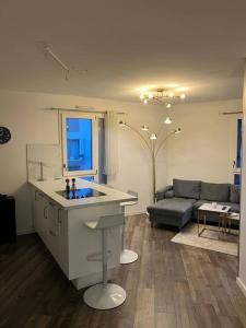 eine Küche und ein Wohnzimmer mit einem Sofa und einem Tisch in der Unterkunft Cosy T2 au porte d’Orly-Rungis in Chevilly-Larue