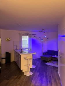 Dieses lila Zimmer verfügt über eine Küche und ein Sofa. in der Unterkunft Cosy T2 au porte d’Orly-Rungis in Chevilly-Larue