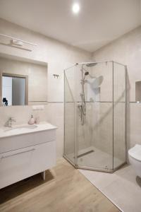 La salle de bains blanche est pourvue d'une douche et d'un lavabo. dans l'établissement CASA ENCIAN, à Colibiţa