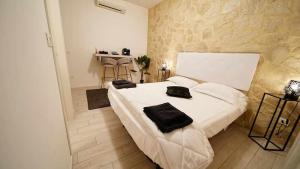 Un dormitorio con una cama blanca con toallas negras. en Langolo di laura borgo roma destiny home 3 en Verona