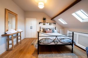 ein Schlafzimmer mit einem Bett im Dachgeschoss in der Unterkunft Stable Cottage in Teffont Magna